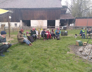 Solawi-Mitglieder essen gemeinsam am Lagerfeuer die Gründonnerstagssuppe.