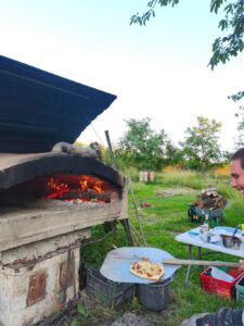 Pizza wird in den steinernen Pizzaofen geschoben